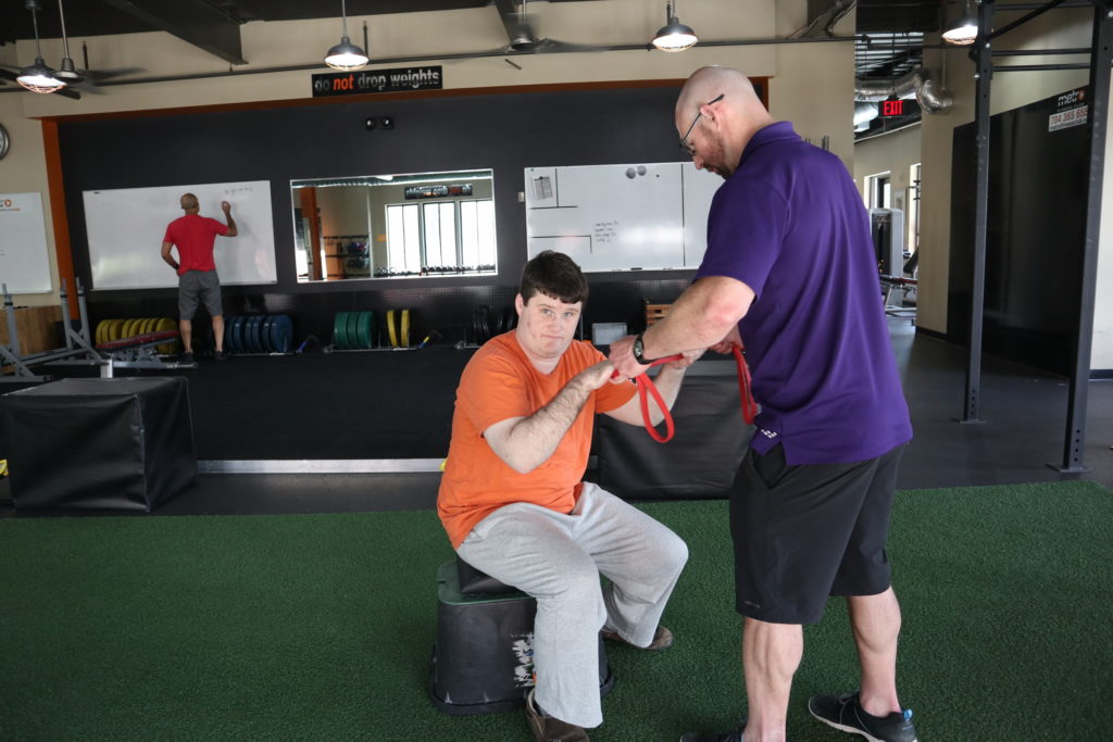 Autism Fitness athlete box squats with Autism Fitness Founder Eric Chessen.